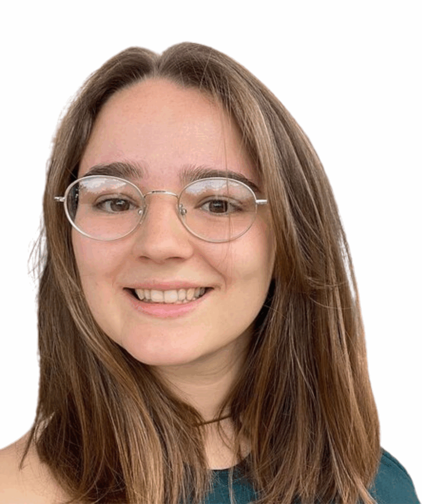Eine weiße Frau mit braunen Haaren und Brille lächelt in die Kamera.
