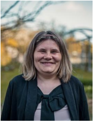 Ein Bild von Franziska Reschke, blonde, halblange Haare, schwarzes Oberteil, lächelnd