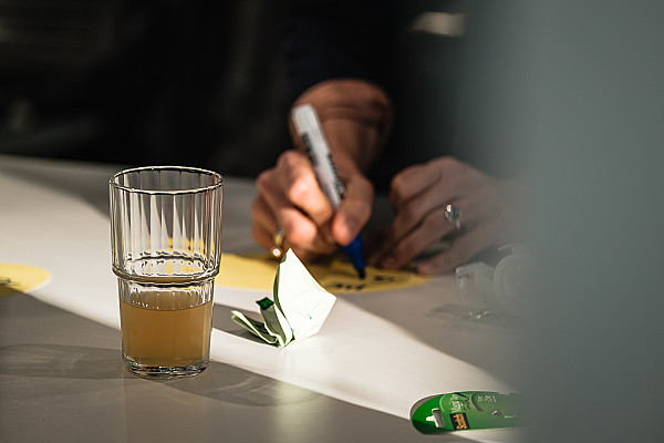 Eine Person schreibt mit einem Filzstift auf eine Karte.